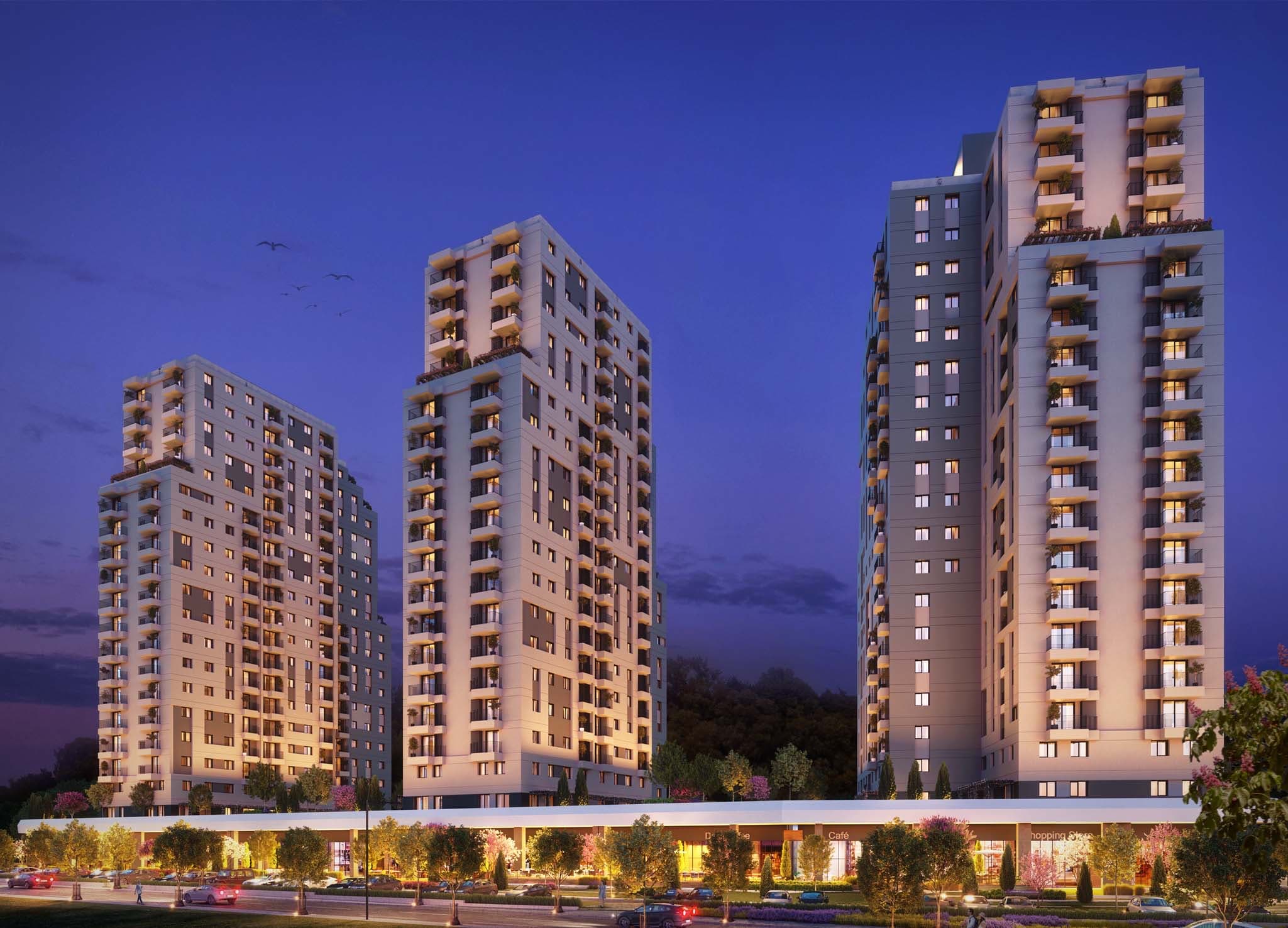 The three AS Concept residential towers lit at dusk above a lit retail street frontage with cafés and shops at ground level — artist's impression