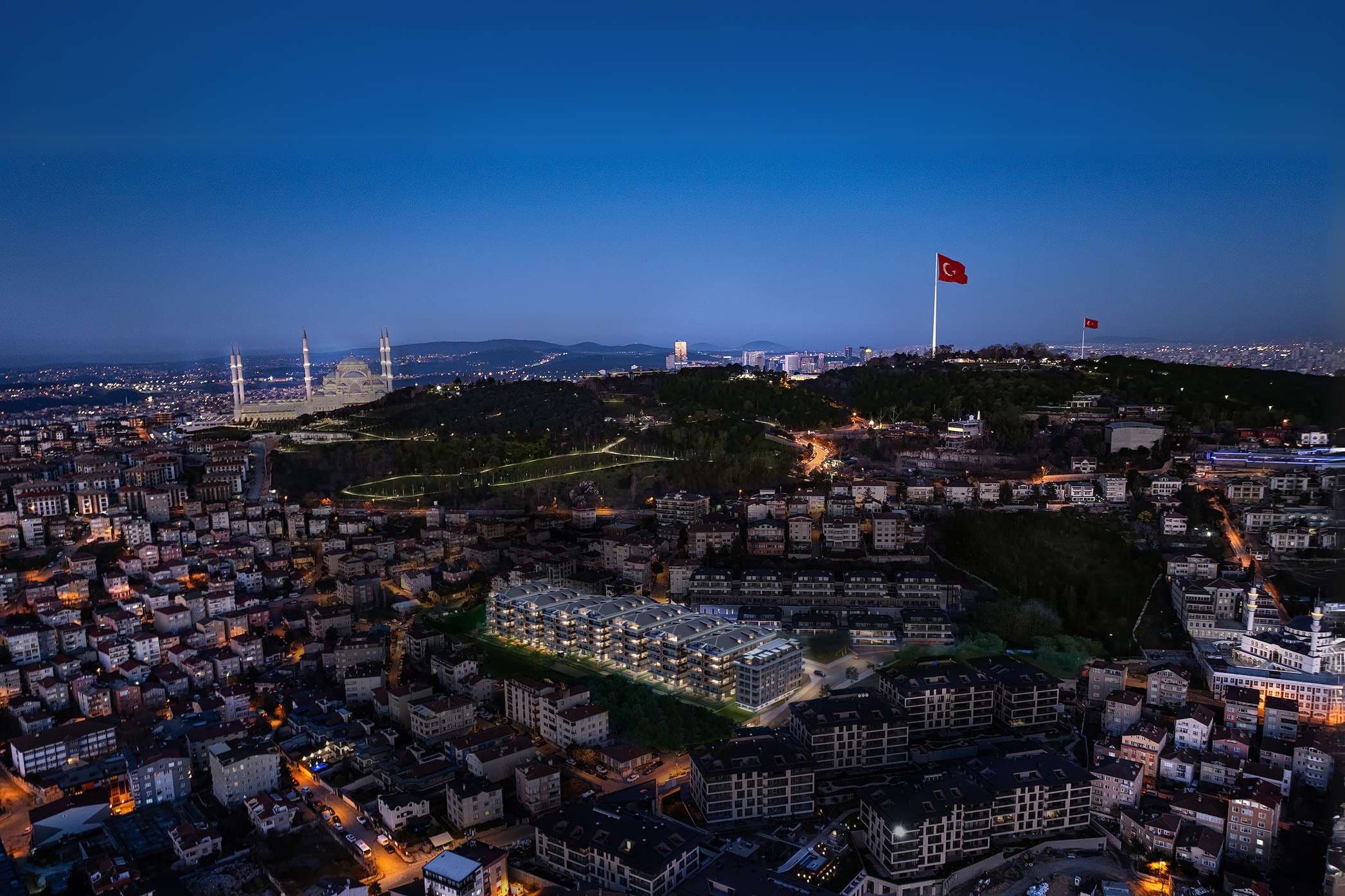 Boğaz Çamlıca lit at blue hour among the rooftops below Büyük Çamlıca, with Çamlıca Mosque and the hilltop flagpoles on the ridge above Üsküdar