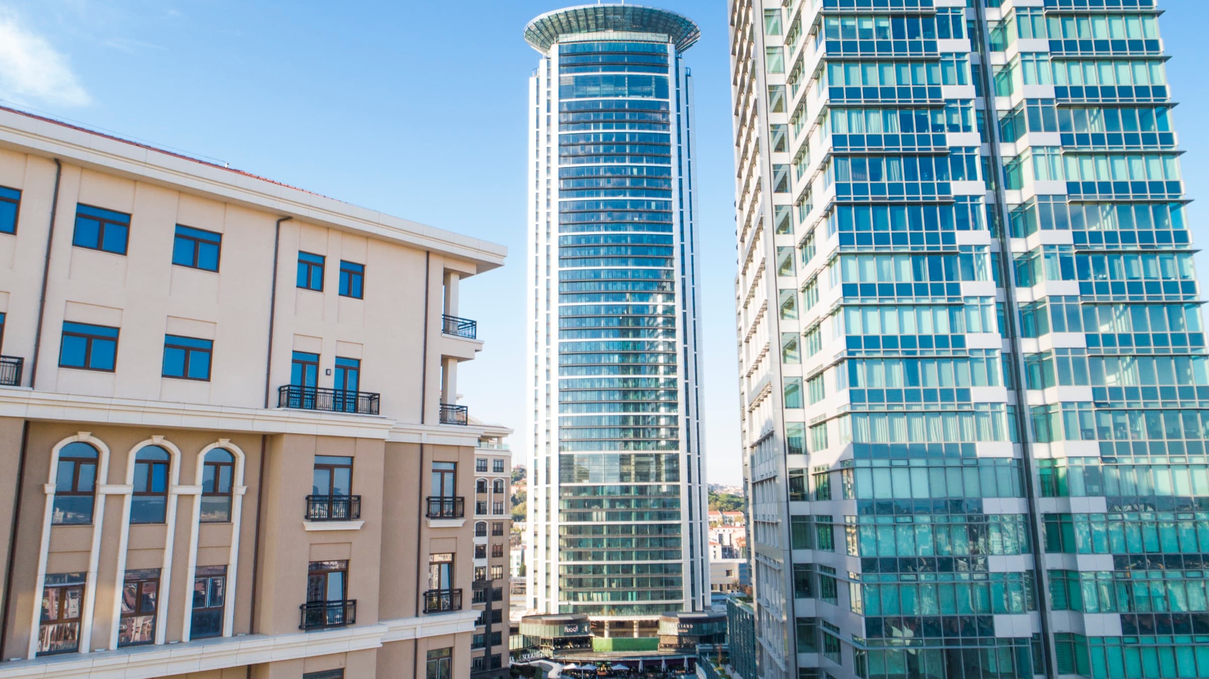 Emaar Square İstanbul's round tower framed between the residence blocks, the retail street running at its base