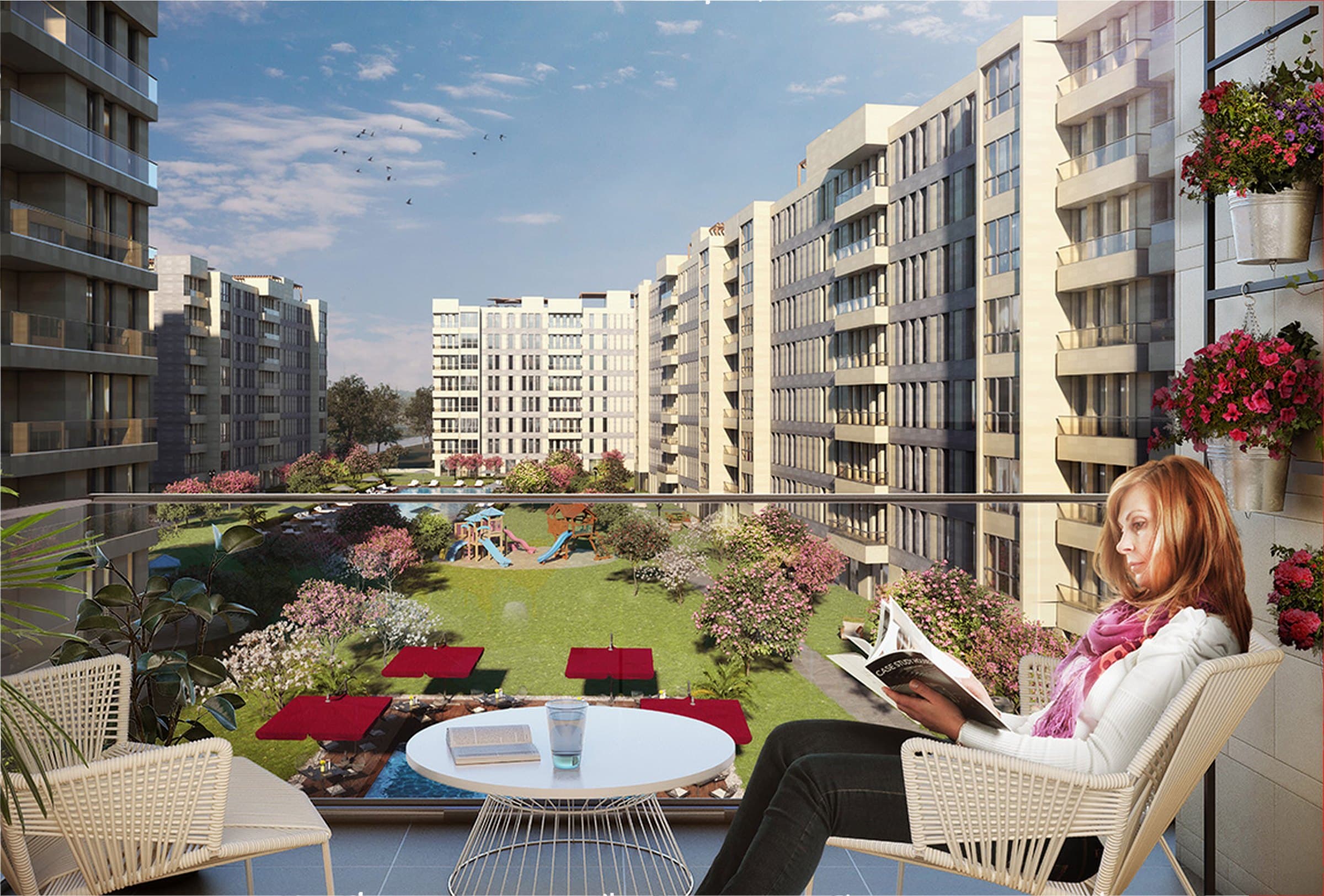 Computer-generated view from a planted balcony over a landscaped courtyard, with a lawn, red sun loungers, a children's play area and flowering trees between the pale seven-storey blocks — artist's impression