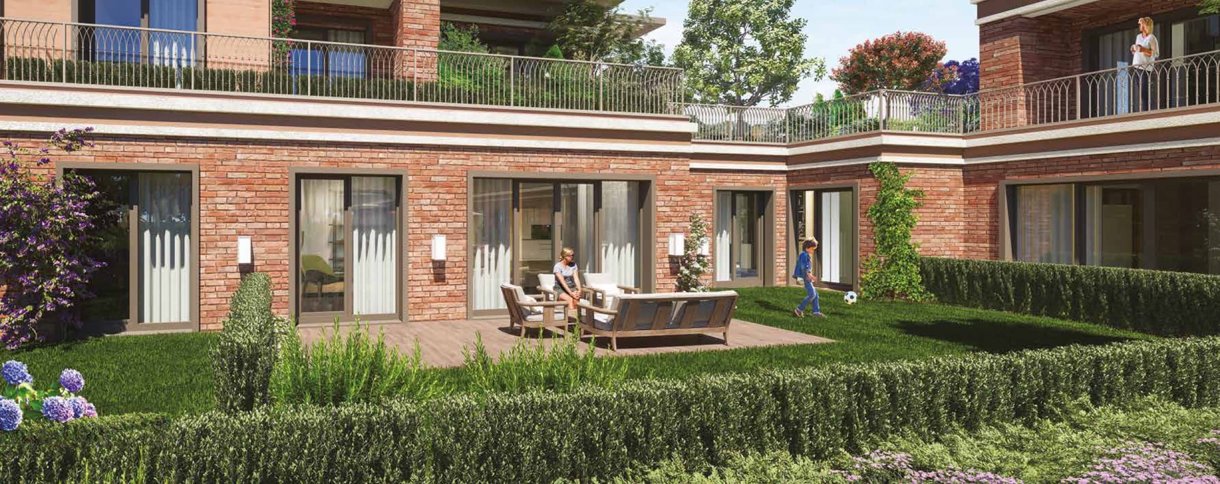 Özak Duyu Göktürk garden floor apartments, full-height glass doors opening onto a timber deck and private lawn enclosed by clipped hedges, with a garden terrace above