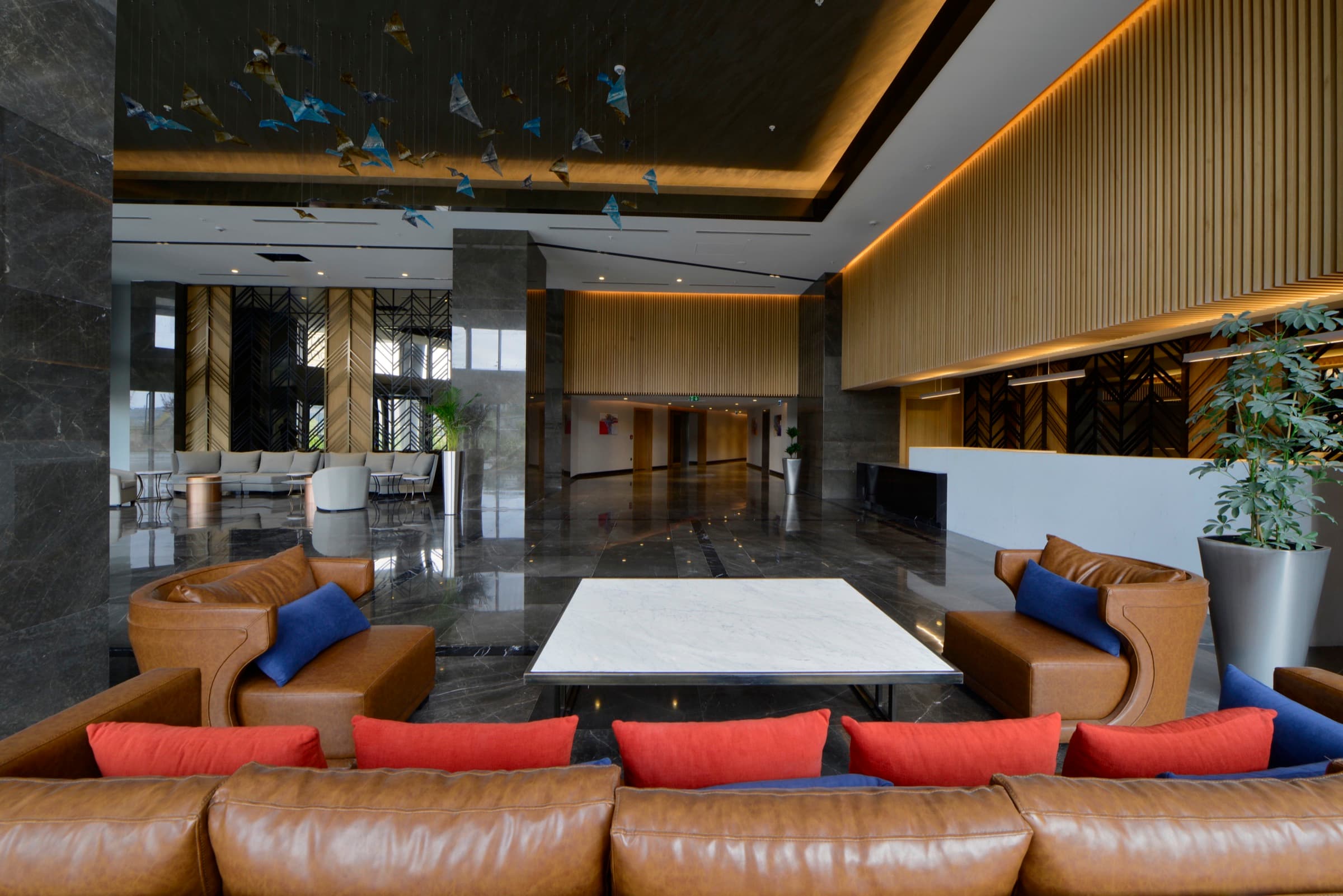 Skyland İstanbul'da Sky Deluxe Residence kulesinin sakin lounge'u; asılı cam kuş enstalasyonunun altında