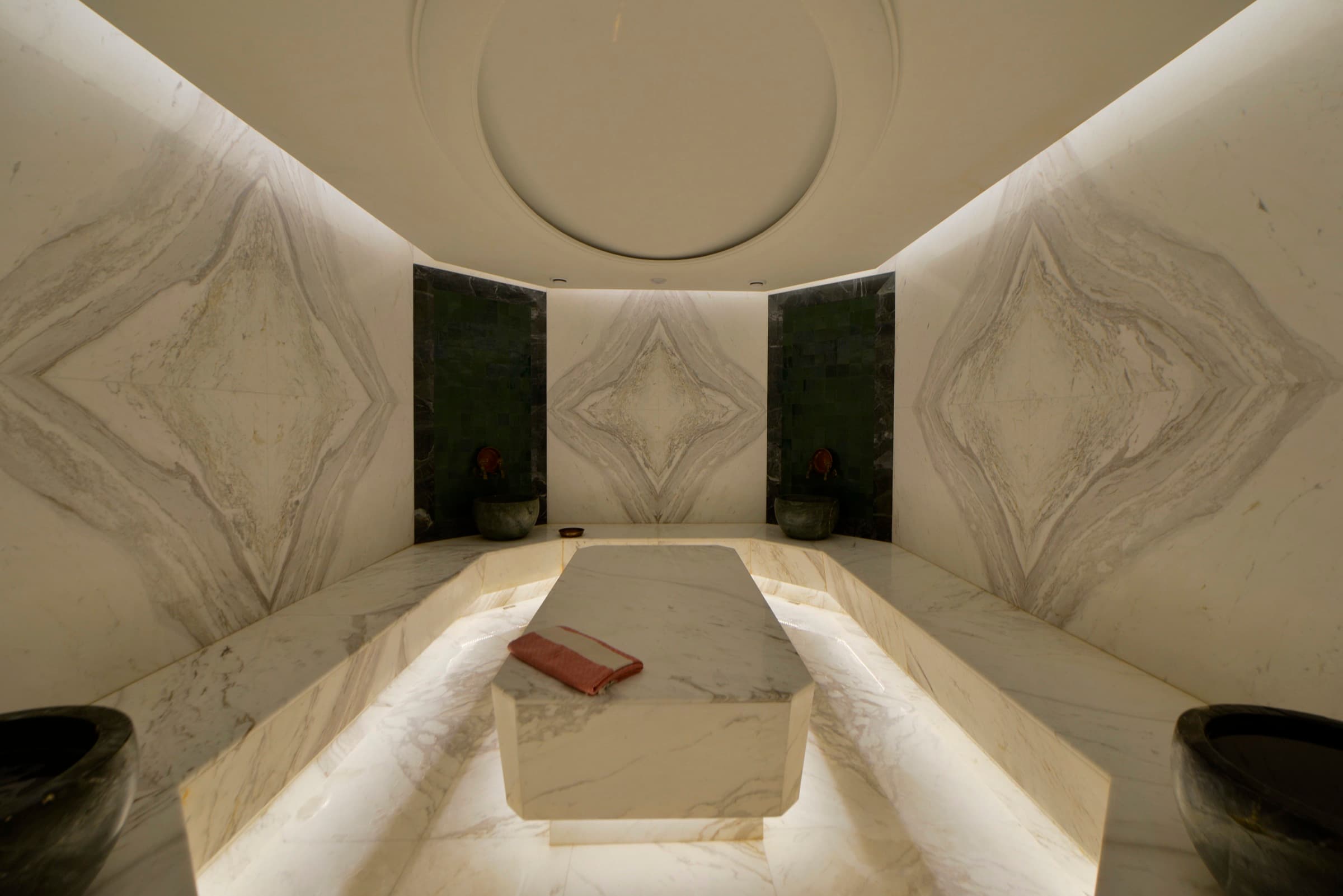 Skyland İstanbul'da Sky Wellness spasında ortasında göbek taşı olan kitap açımı mermer hamam