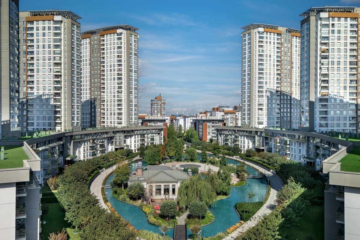 Curved water channel and landscaped central garden enclosed by the crescent blocks and towers of Tema İstanbul