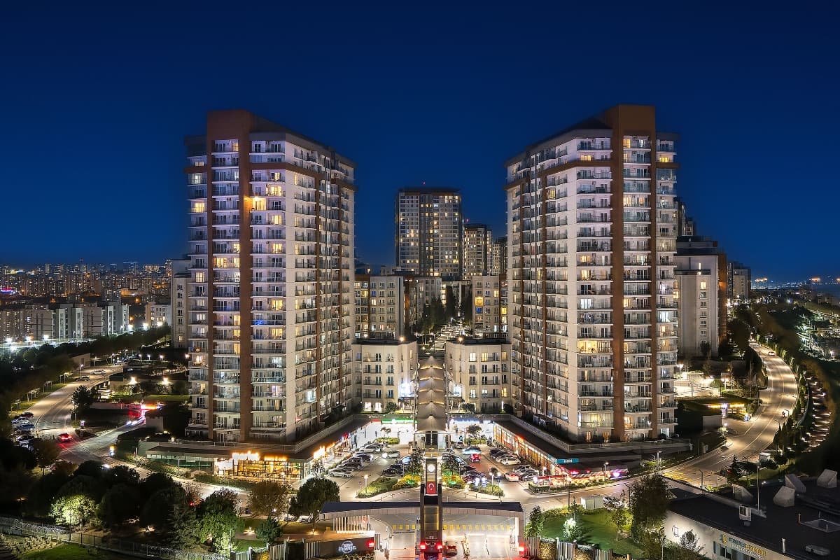 Tema İstanbul at blue hour, its towers lit above the ground-level shops and cafés of the central plaza