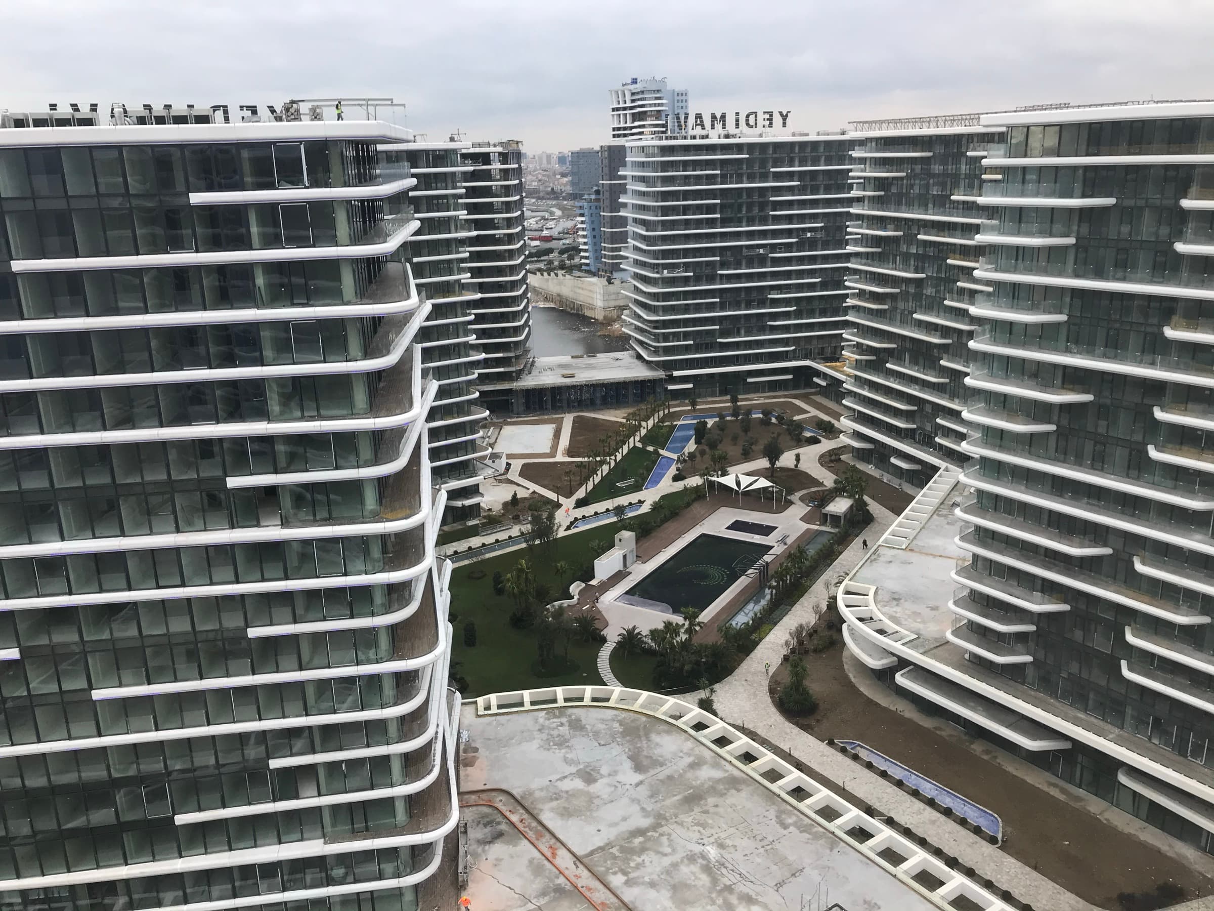 The courtyard at Yedi Mavi from an upper floor, with lawns, a rectangular pool and narrow water channels enclosed by the residential blocks, Kazlıçeşme, Istanbul