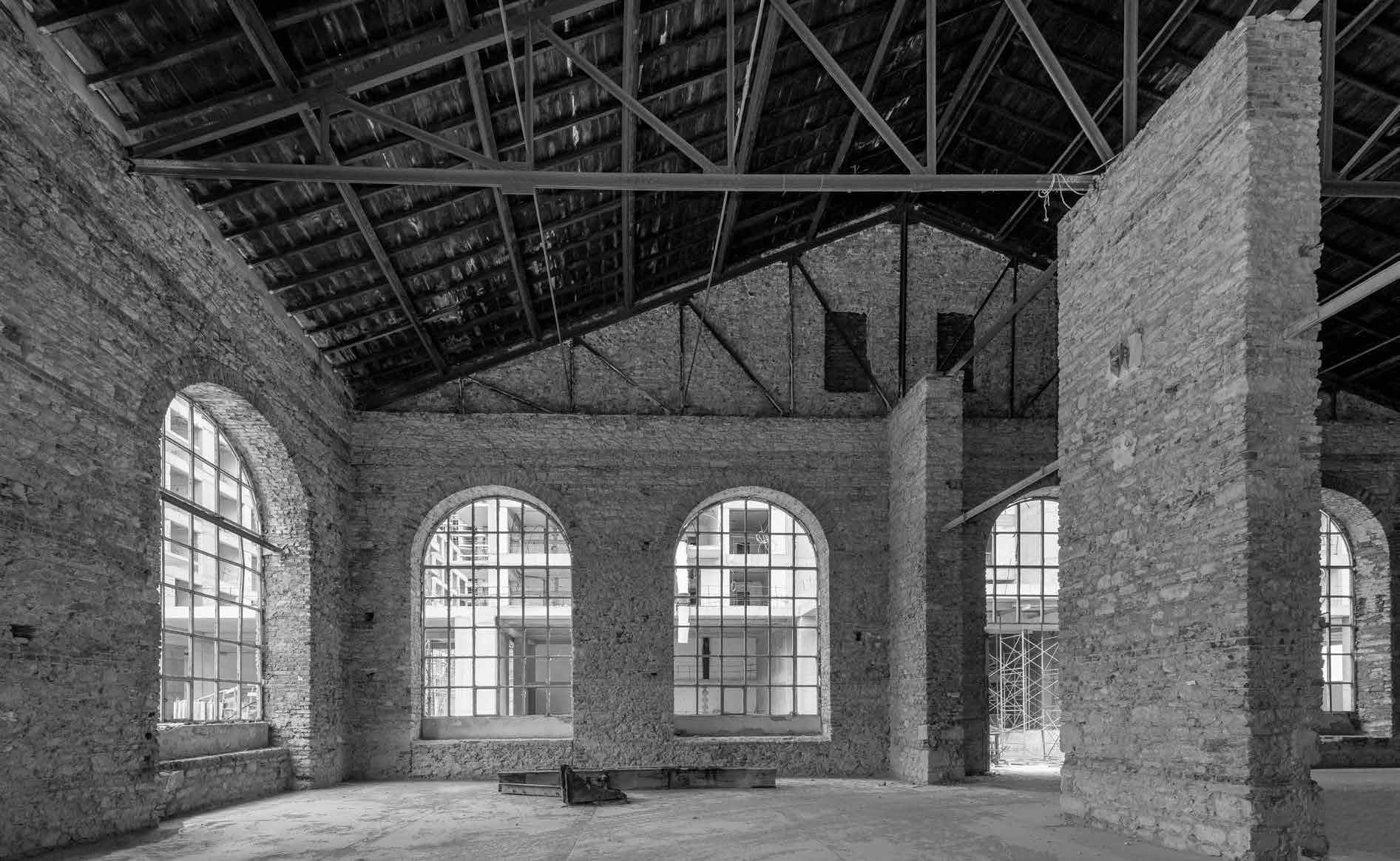 Monochrome view inside the Fişekhane building showing arched windows and exposed timber roof trusses